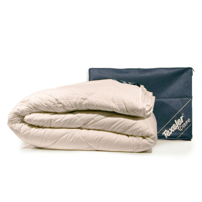 A beige Texeler Wonderwool Comforter folded and placed in front of its blue packaging with the brand name visible.