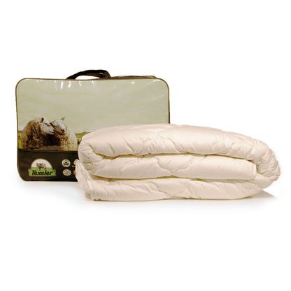A beige Texeler Multi Choice comforter displayed in front of its packaging, which features an image of sheep on a green landscape. The comforter appears to be made of cotton and wool. 400 gram