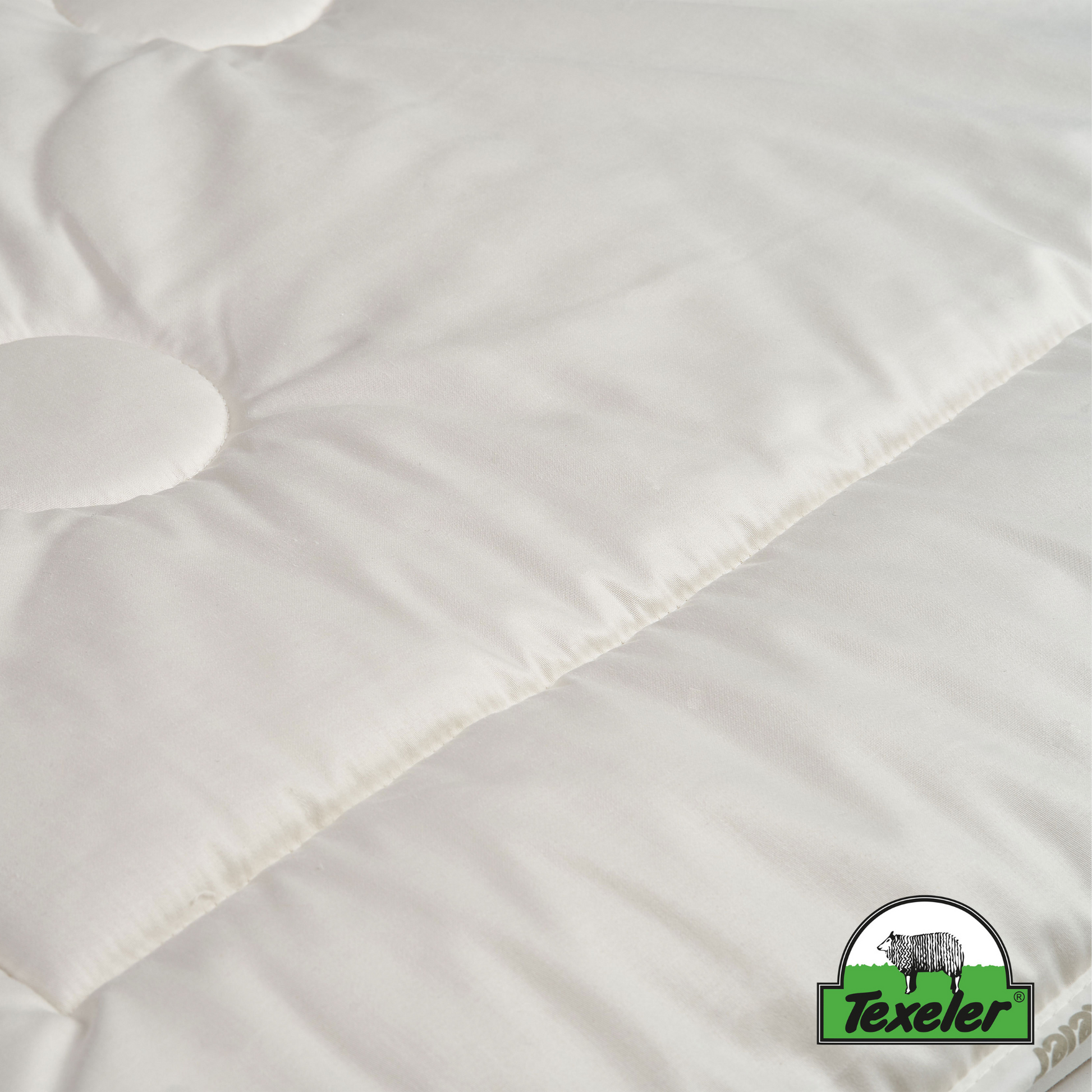 a close-up of the texeler sleep well satin wool comforter to showcase the cover of the comforter